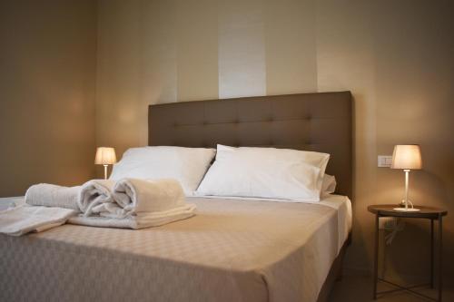 sypialnia z łóżkiem z ręcznikami w obiekcie Le Quiete Stanze, vacancy houses posto spiaggia in omaggio w mieście Numana