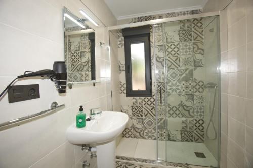 a bathroom with a sink and a shower at Apartamentos La Cueva - Onis in Avín