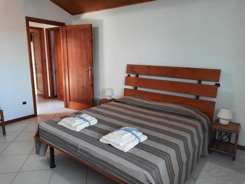 CASA CATY - Oristano في أوريستانو: غرفة نوم عليها سرير وفوط