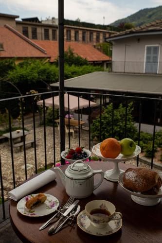 a table with plates of food on a balcony at Maison Flipot in Torre Pellice