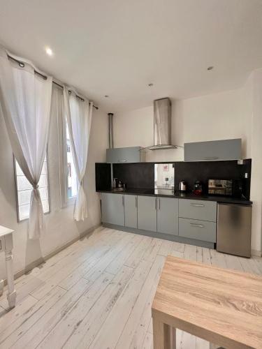 Il comprend une cuisine avec des murs blancs et du parquet. dans l'établissement Grand studio climatisé à 3min des plages de Juan les pins, à Juan-les-Pins