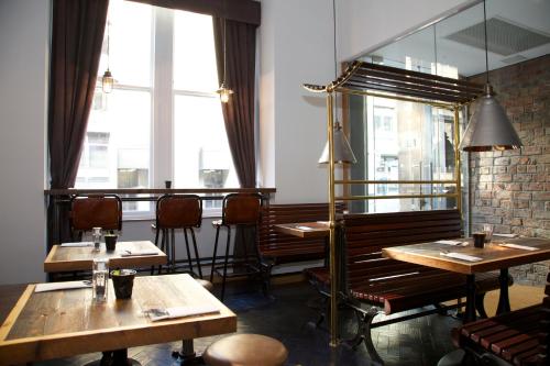 a restaurant with wooden tables and chairs and windows at The Z Hotel Glasgow in Glasgow