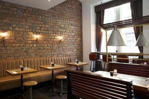 a restaurant with wooden tables and a brick wall at The Z Hotel Glasgow in Glasgow