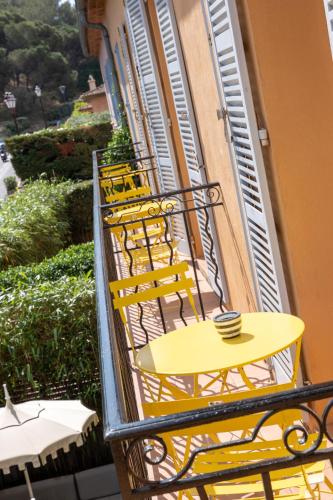 a yellow table and chairs on a balcony at Hôtel Le Y in Saint-Tropez