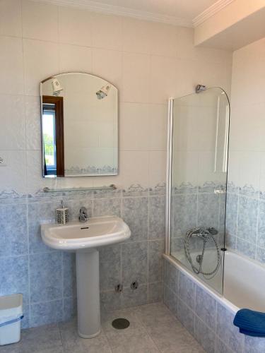 a bathroom with a sink and a shower with a mirror at Hostal La Concha Somo in Somo