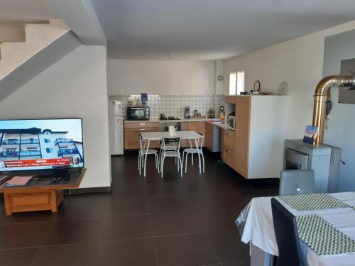 Il comprend une cuisine et une salle à manger avec une table et une télévision. dans l'établissement Villa Maison Cévennes et Sud Ardèche, à Bessèges