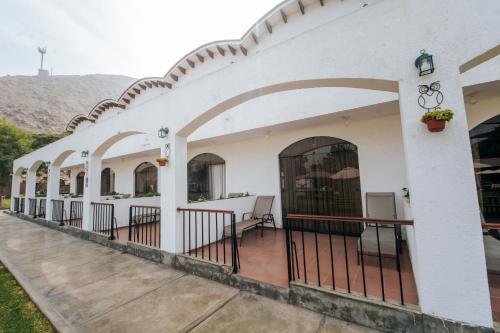 a white building with arches and a patio at VPX Hoteles Cieneguilla in Cieneguilla