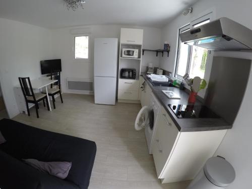 une cuisine avec un réfrigérateur blanc et une table dans l'établissement Beau T2 neuf au calme entre mer et montagne, à Bassussarry