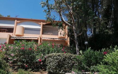 une maison avec un balcon et quelques buissons et fleurs dans l'établissement Charmant studio climatisé pinède 1 min de la mer, à Sanary-sur-Mer