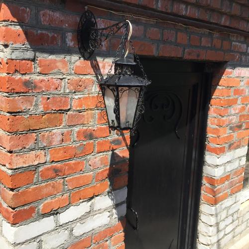 a black lantern hanging on a brick wall at Apple Tree Family Home (ECO) in Dzorakap