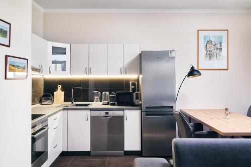 a kitchen with a stainless steel refrigerator and a table at Apartman Residence Moser 1504 in Karlovy Vary