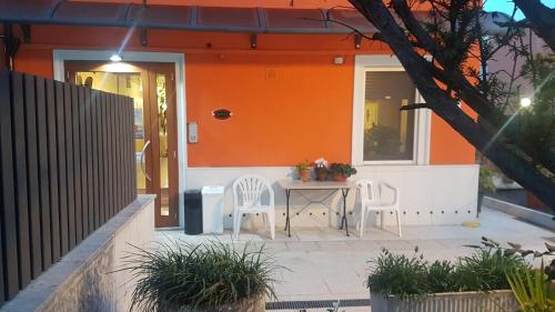 een oranje huis met een tafel en stoelen op een patio bij Hotel Siros in Verona