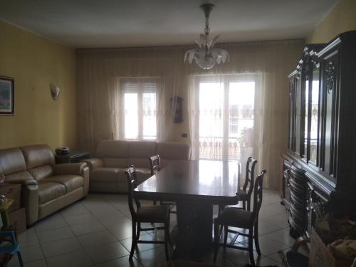 ein Wohnzimmer mit einem Tisch, Stühlen und einem Sofa in der Unterkunft Casa Carlo&Luisa in Pescara