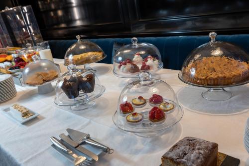 a table with several plates of desserts and cakes at Hôtel Le Y in Saint-Tropez