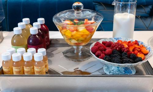 a tray with a bowl of fruit and a drink at Hôtel Le Y in Saint-Tropez