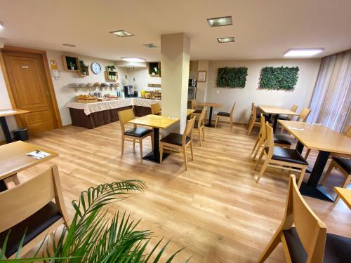 a restaurant with wooden tables and chairs and a counter at Hotel Ribeira Sacra in Monforte de Lemos