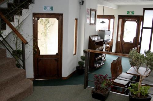 una sala de estar con una puerta y algunas plantas en HB Express Hotel, en Tlaxcala de Xicohténcatl