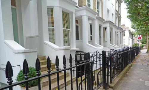 a black fence in front of a white house at Boutique Barclay House London townhouse - West London, Kensington, Chelsea, Fulham in London