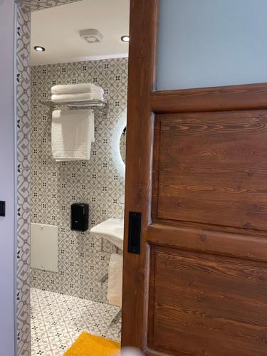 a bathroom with a wooden door in a bathroom at Utopia Luxury Suites - Old Town in Rhodes Town