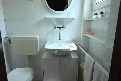 a bathroom with a sink and a toilet and a mirror at Guesthouse Klaric in Rovinj