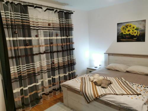 a bedroom with a bed and a curtain at Apartman San in Vrnjačka Banja