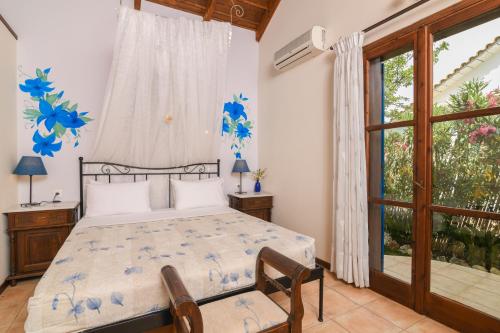 a bedroom with a bed and a large window at Therianos Traditional Villas in Kallithea