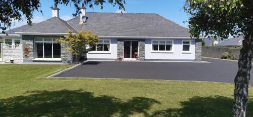 a house with a driveway in front of it at Green Acres Guesthouse- Accommodation Only in Killarney