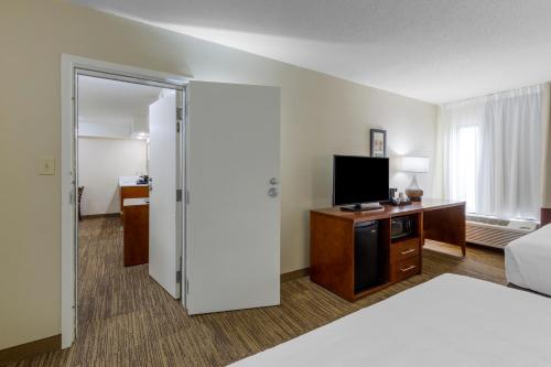 a hotel room with a bed and a flat screen tv at Comfort Inn University Durham - Chapel Hill in Durham