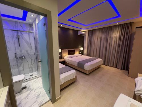 a hotel room with two beds and a bathroom at Phaethon Apartments & Studios in Kallithea Halkidikis