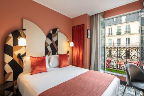 una camera d'albergo con letto e finestra di Royal Saint Germain a Parigi