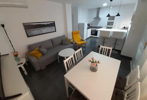 sala de estar con mesa blanca y sofá en La Casita, en Málaga
