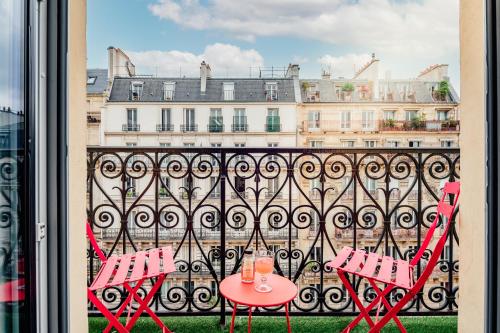 - deux chaises rouges et une table sur un balcon dans l'établissement Royal Saint Germain, à Paris
