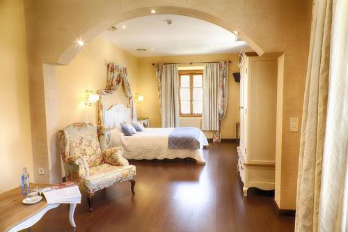 1 dormitorio con 1 cama y 1 silla en una habitación en Hotel San Antón Abad, en Villafranca Montes de Oca