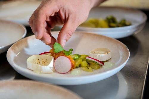 a person is reaching for a plate of food at Hotel Kühberg in Oberstdorf