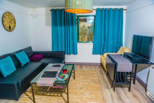 un soggiorno con divano nero e tende blu di 1 bedroom apartment by Trinity a Dublino