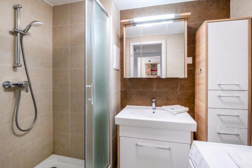 a bathroom with a white sink and a shower at MF SilverBeach 112 Apartment in Siófok