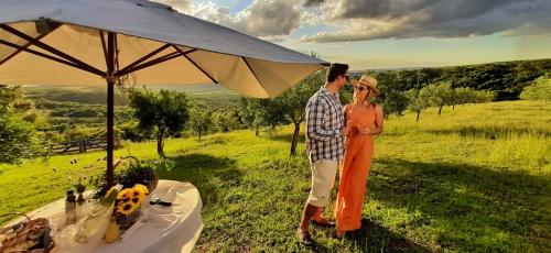a man and a woman standing under an umbrella at Pousada Olival Vila do Segredo in Caçapava do Sul