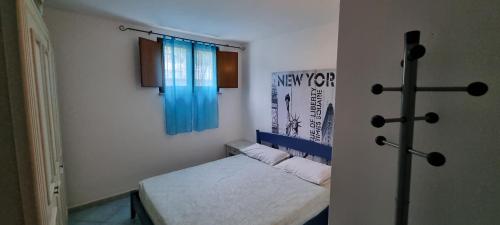 トルトリにあるAppartamento Tortolìのベッド1台(壁にクロス付)が備わる客室です。