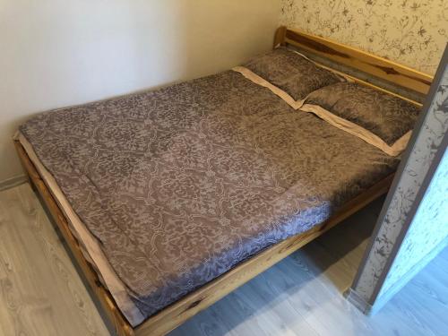 a bed in a room with a wooden frame at Janshevska 7/9 in Liepāja