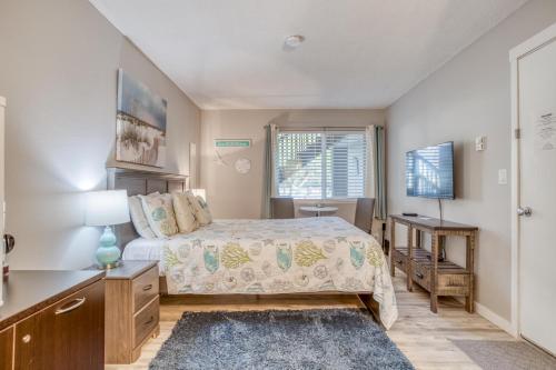 a bedroom with a bed and a desk and a window at Beach Captain - Meredith Lodging in Neskowin