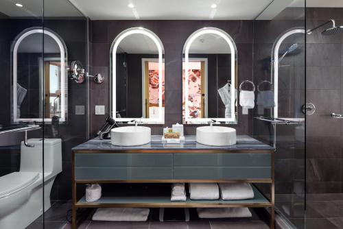 a bathroom with two sinks and two mirrors at Versante Hotel in Richmond
