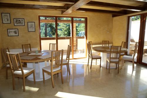 a dining room with tables and chairs and windows at Villa Ema in Panichishte