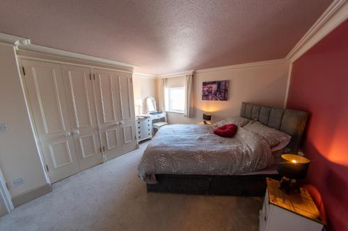 Un dormitorio con una cama con una almohada roja. en 3, The Dolphin, 49 Quay Street - Stunning apartment - Quintessential - Quay views - Sleeps 2-4 people, en Newport
