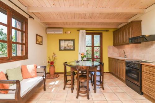 a kitchen with a table and a couch at Therianos Traditional Villas in Kallithea