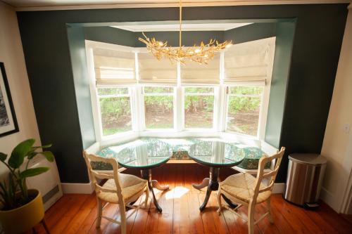 a dining room with a glass table and chairs and a window at Yellow House Inn in Bar Harbor