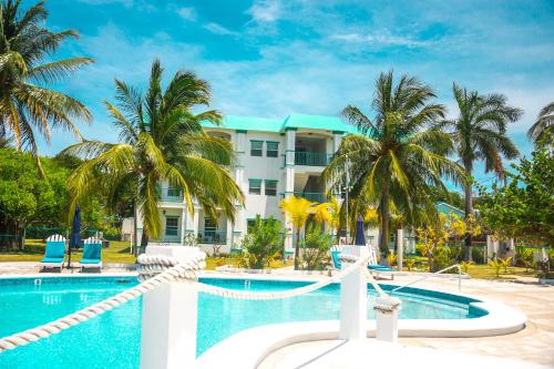 a resort with a swimming pool and palm trees at Best Western Grand Baymen Gardens in San Pedro