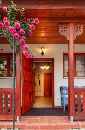a front door of a house with pink roses at Rózsa Apartman Aggtelek in Aggtelek