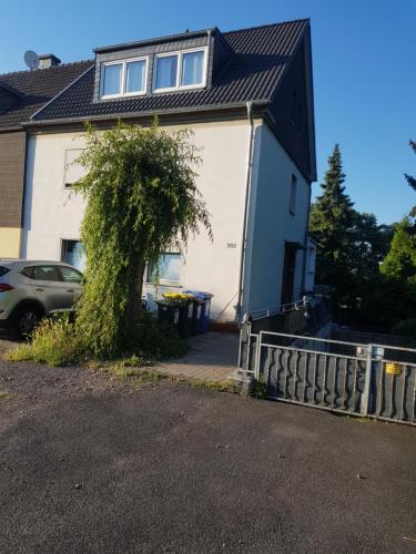 a house with a tree in front of it at Appartment Analena in Meerbusch