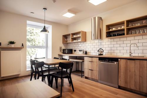 a kitchen with a wooden table and chairs and a counter at Fotel Mikołowska in Tychy