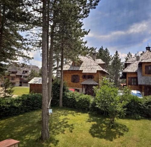 a group of houses with trees in a yard at Vila Milovanovic TARA in Bajina Bašta